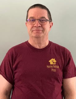 Dennis in his employee t-shirt that is maroon and yellow. 